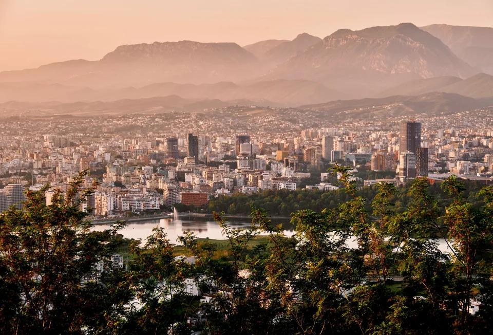 Tirana spread below the mountains in evening light